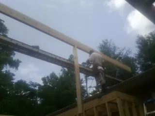 Carpenter setting a ridge beam over a new addition frame — Ice Dam Removal by Roofing Brothers in Macks Inn