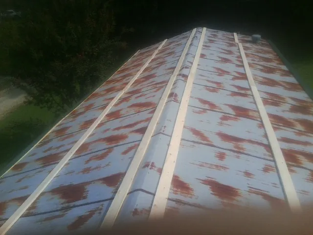 Rusted metal roof panels with new wood purlins before replacement — Storm Damage Roof Repair in Macks Inn by Roofing Brothers